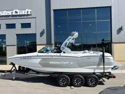 Slide: The Image of 2021 MasterCraft XStar boat on trailer outside dealership. - 1