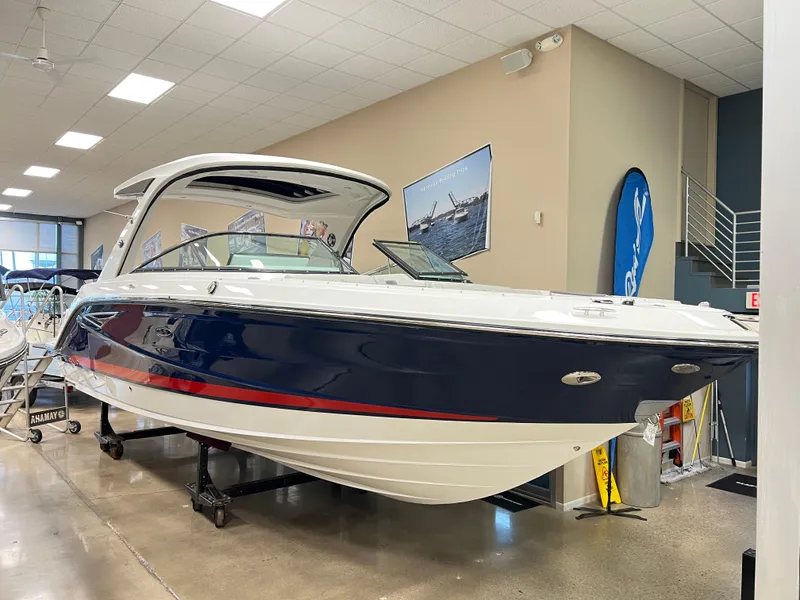The Image of 2025 Sea Ray SLX 310 boat displayed indoors, featuring sleek design and modern amenities. - 0