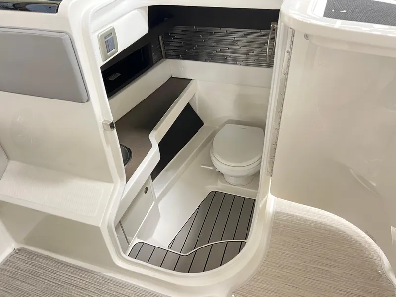 Slide: The Image of Interior of 2025 Sea Ray SLX 310 boat featuring a compact bathroom. - 11