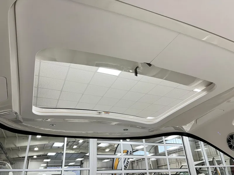 Slide: The Image of 2025 Sea Ray SLX 310 boat interior ceiling with skylight in showroom. - 16