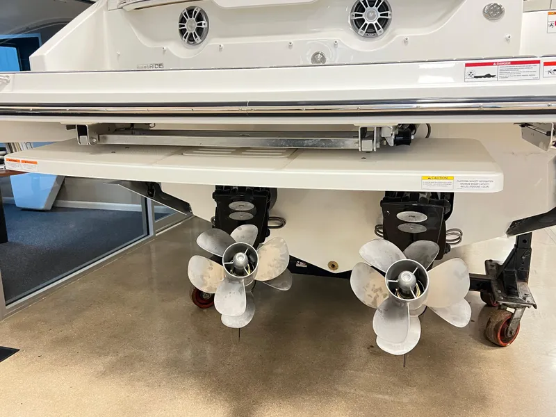 Slide: The Image of 2025 Sea Ray SLX 310 boat propellers and stern view in showroom. - 4