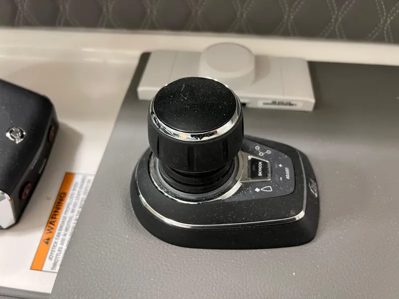 Slide: The Image of Joystick control on 2025 Sea Ray SLX 310 boat dashboard. - 9