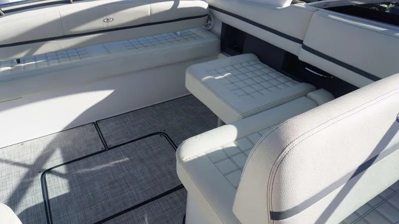 Slide: The Image of 2020 Cobalt 30 SC boat interior with white cushioned seating and gray flooring. - 12