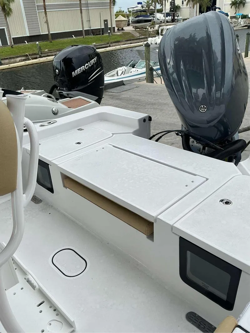 Slide: The Image of 2025 Sportsman 227 MASTERS boat with dual outboard motors at a marina. - 9