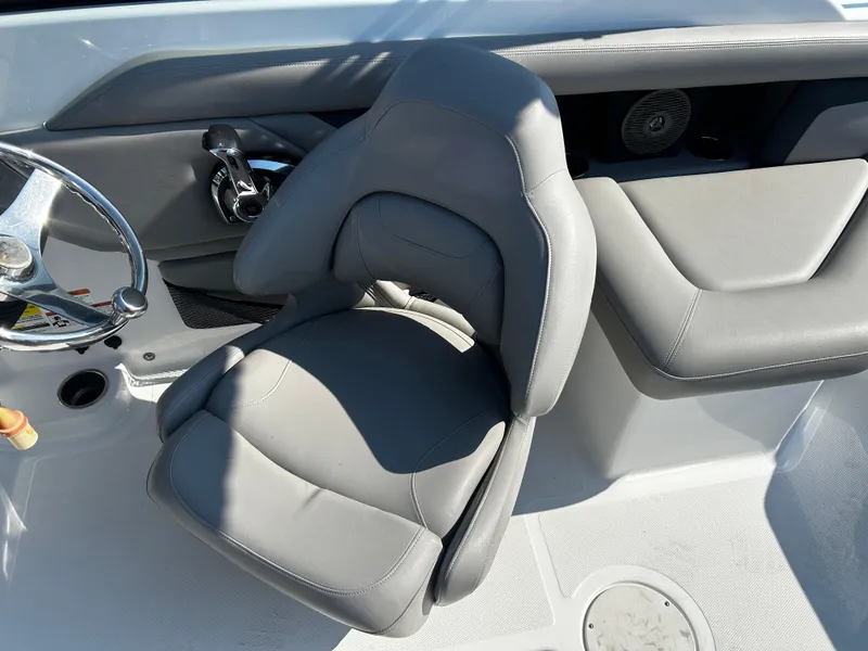 Slide: The Image of 2023 Four Winns HD3 OB boat interior with gray captain's chair and steering wheel. - 12