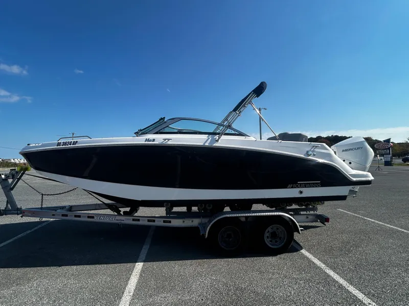 Slide: The Image of 2023 Four Winns HD3 OB boat on trailer under clear blue sky. - 3