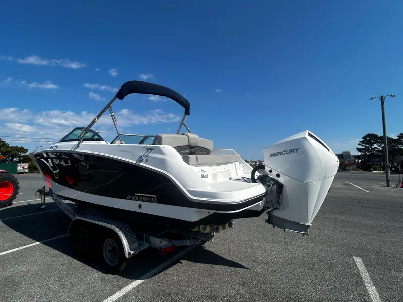 Slide: The Image of 2023 Four Winns HD3 OB boat with Mercury outboard engine in parking lot. - 4