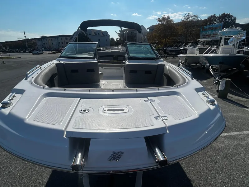 Slide: The Image of 2023 Four Winns HD3 OB boat, sleek design, parked outdoors under clear sky. - 5