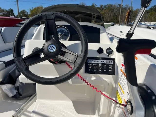 Slide: The Image of 2023 Bayliner Element M15 boat dashboard with steering wheel and control panel. - 3