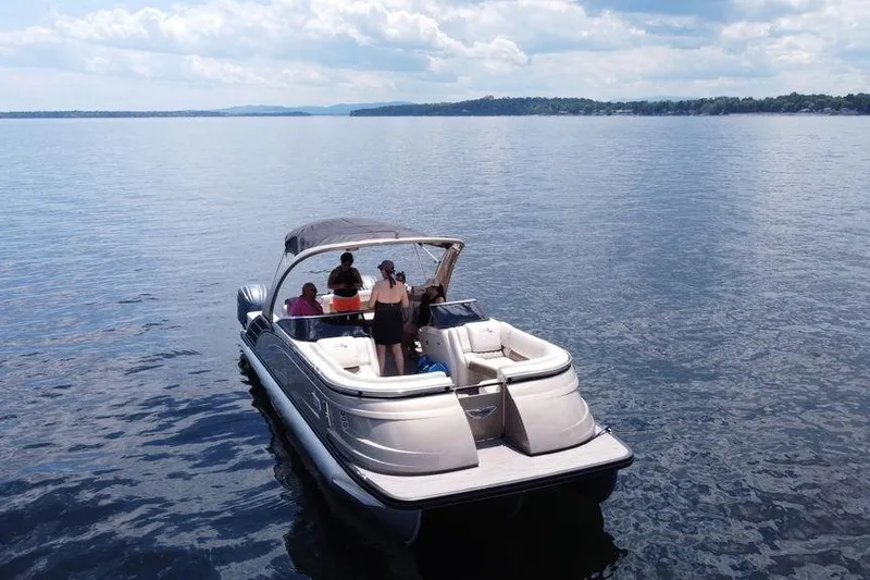 Slide: The Image of 2021 Bennington 27 QXSBWA X2 boat with dual outboard motors near a boathouse. - 14