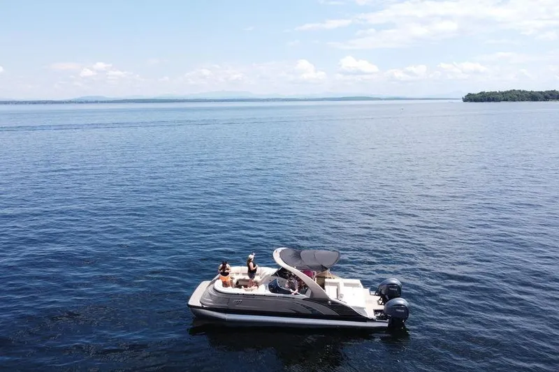 Slide: The Image of 2021 Bennington 27 QXSBWA X2 pontoon boat with dual 300 V6 engines, docked by a lake. - 17