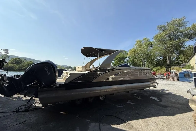 Slide: The Image of 2021 Bennington 27 QXSBWA X2 boat detail with sleek metallic design and emblem. - 22