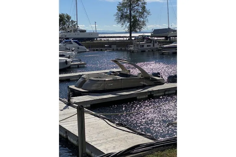 Slide: The Image of 2021 Bennington 27 QXSBWA X2 pontoon boat docked in a sunny marina. - 54