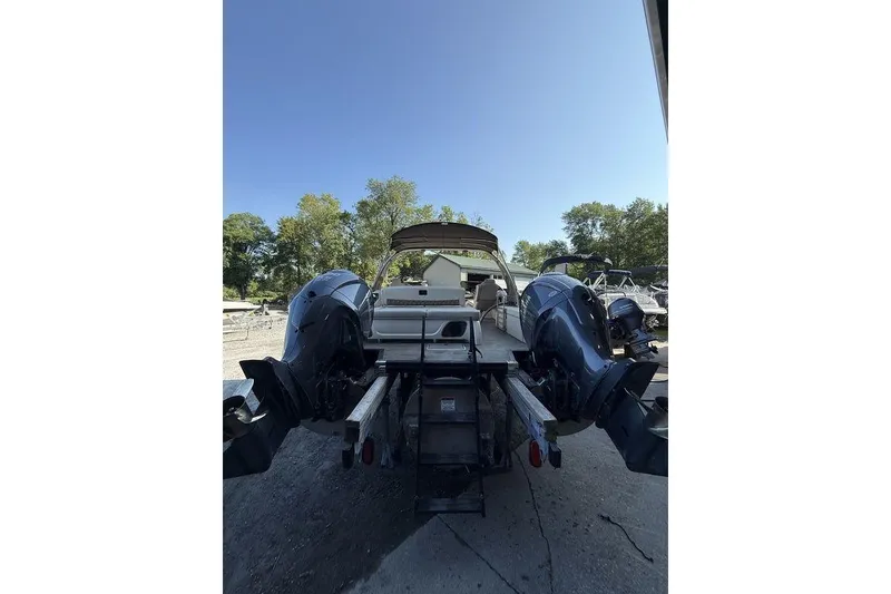 Slide: The Image of 2021 Bennington 27 QXSBWA X2 boat with dual engines, parked outdoors. - 55