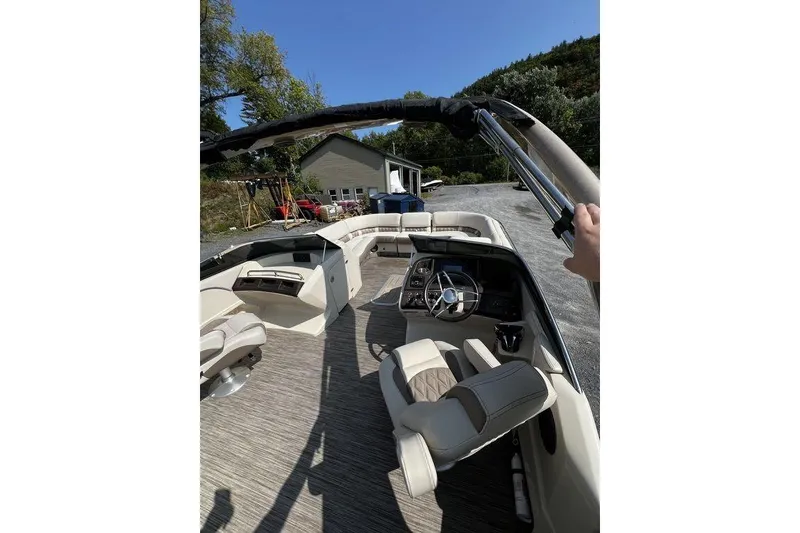 Slide: The Image of 2021 Bennington 27 QXSBWA X2 boat interior with steering wheel and seating, parked outdoors. - 56