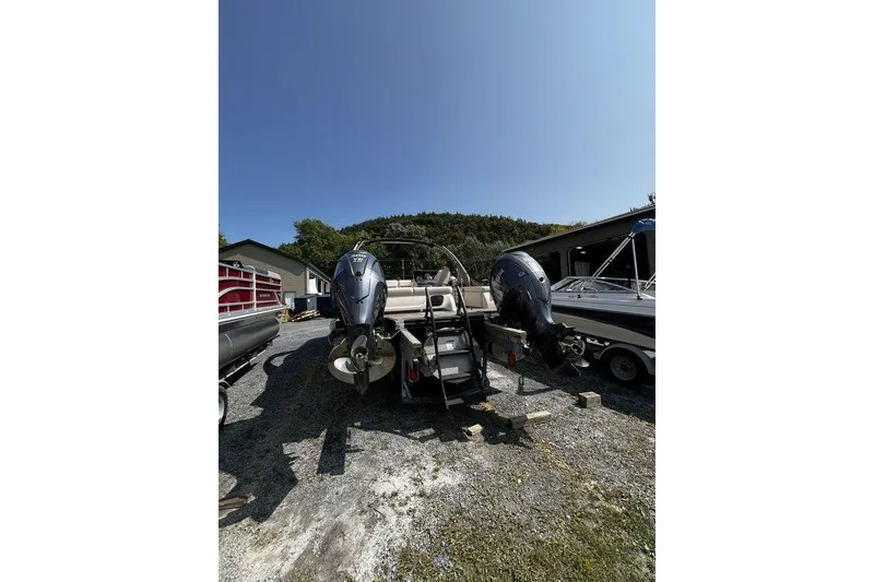 Slide: The Image of 2021 Bennington 27 QXSBWA X2 pontoon boat with dual outboard motors, parked outdoors. - 62