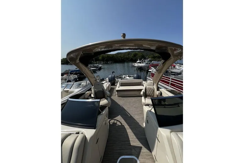 Slide: The Image of 2021 Bennington 27 QXSBWA X2 luxury pontoon boat docked at a scenic marina. - 68