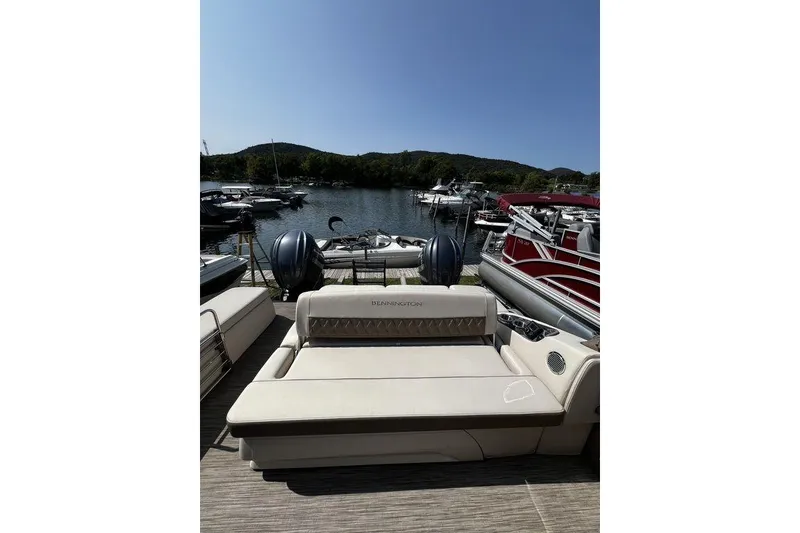 Slide: The Image of 2021 Bennington 27 QXSBWA X2 pontoon boat docked by a scenic lake. - 71