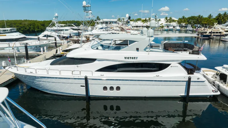 Slide: The Image of 2008 Hatteras 80 Motor Yacht docked at a marina under a clear blue sky. - 1
