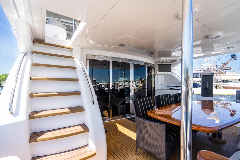 Slide: The Image of 2008 Hatteras 80 Motor Yacht aft deck with stairs, dining area, and marina view. - 28