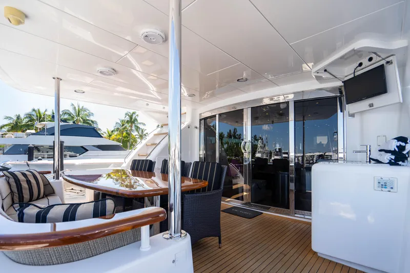 Slide: The Image of 2008 Hatteras 80 Motor Yacht deck with seating, table, and outdoor TV. - 29