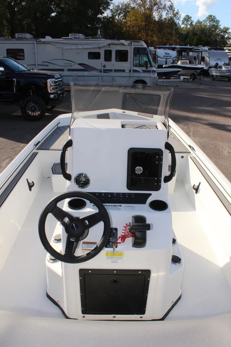 Slide: The Image of 2026 Avid 20 Rogue CC boat interior with storage compartments, parked near a pickup truck. - 16