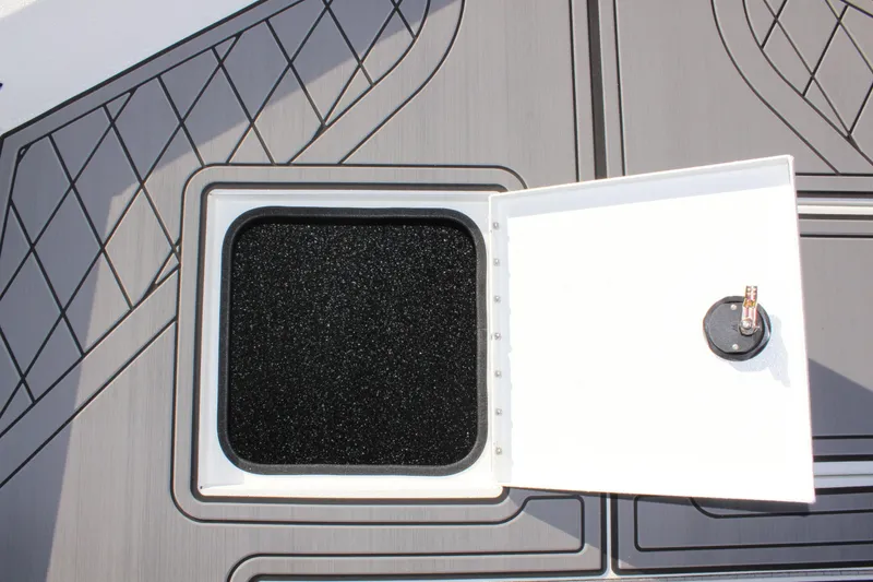 Slide: The Image of 2026 Avid 20 Rogue CC boat interior with seating and console, parked near a building. - 24