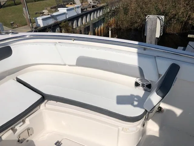 Slide: The Image of 2022 Robalo R242 Center Console boat seating area with speaker, docked near water. - 10