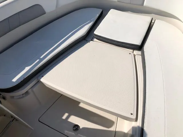 Slide: The Image of 2022 Robalo R242 Center Console boat interior seating area. - 12