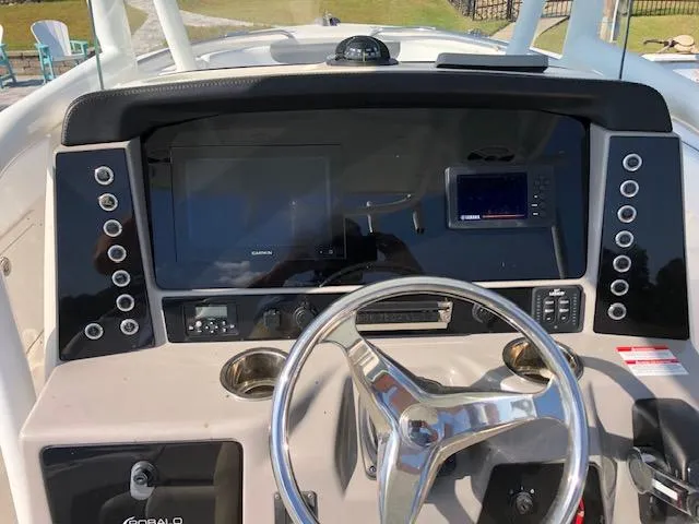 Slide: The Image of 2022 Robalo R242 Center Console boat dashboard with steering wheel and electronic displays. - 18