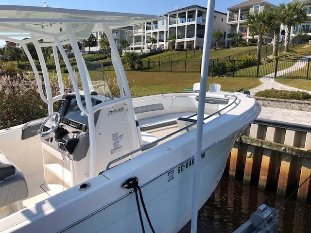 Slide: The Image of 2022 Robalo R242 Center Console boat docked near waterfront homes. - 2