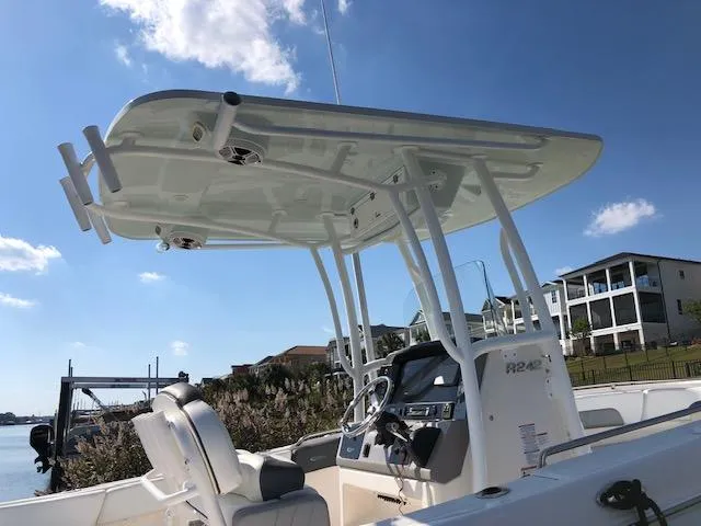 Slide: The Image of 2022 Robalo R242 Center Console boat with T-top, docked near waterfront homes. - 8