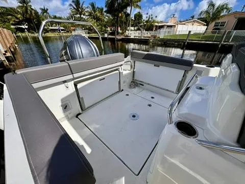 Slide: The Image of 2023 Jeanneau Leader 7.5 CC Series 3 boat interior with seating, docked by a canal. - 24