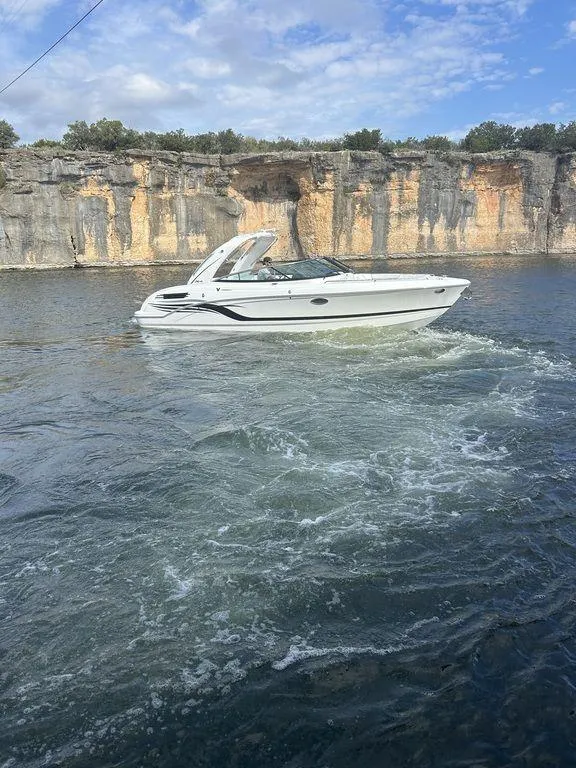 The Image of 2025 Formula 290 Bowrider cruising on a scenic lake with rocky cliffs. - 1
