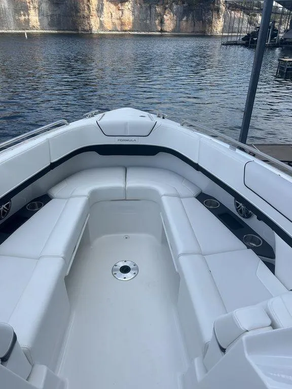 Slide: The Image of 2025 Formula 290 Bowrider boat with spacious seating, docked by a serene lake. - 16