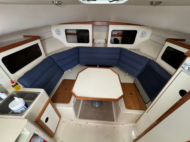 Slide: The Image of 2003 Albin 28 TE Flush Deck interior with blue seating and central table. - 19