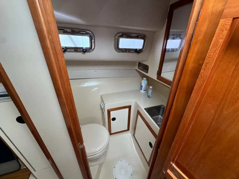 Slide: The Image of 2003 Albin 28 TE Flush Deck boat bathroom with sink, toilet, and wooden cabinetry. - 23