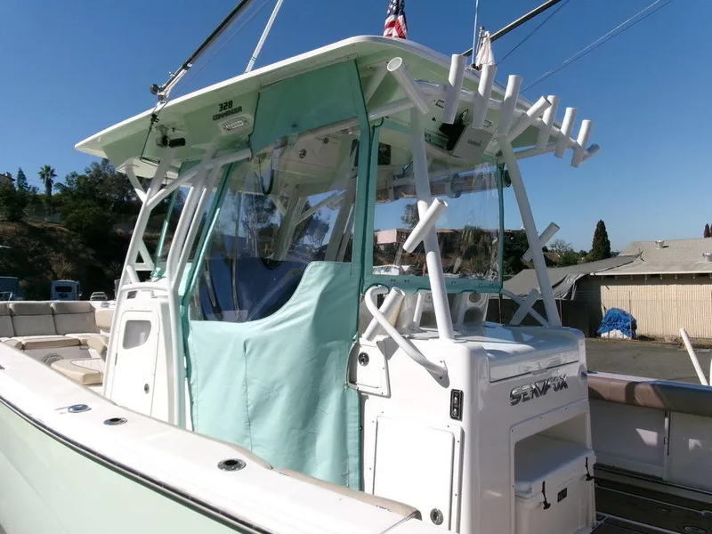 Slide: The Image of 2018 Sea Fox 328 Commander boat with rod holders and canopy, docked outdoors. - 18