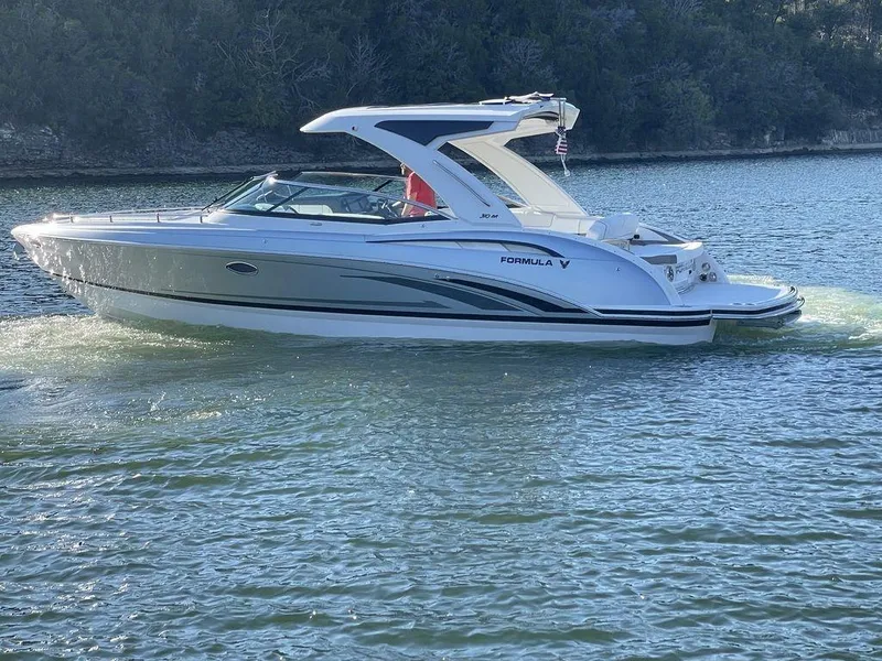 Slide: The Image of 2025 Formula 310 Bowrider cruising on a serene lake with lush greenery. - 3