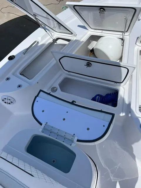Slide: The Image of 2023 Sportsman Masters 227 Bay Boat with open storage compartments and seating area. - 12