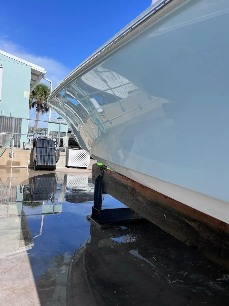 Slide: The Image of 2023 Sportsman Masters 227 Bay Boat on dock, reflecting in water. - 22