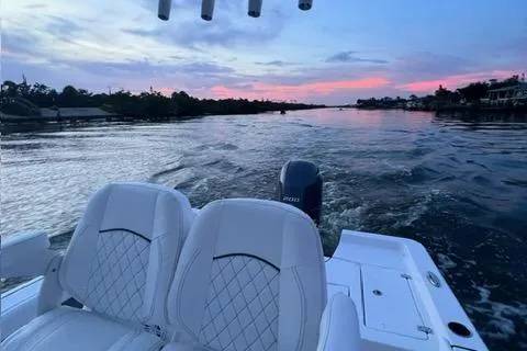 Slide: The Image of 2023 Sportsman Masters 227 Bay Boat cruising at sunset on a serene waterway. - 6