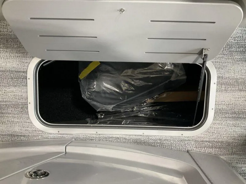 Slide: The Image of Storage compartment in 2025 Bennington 23 RSB boat, open with visible contents. - 11