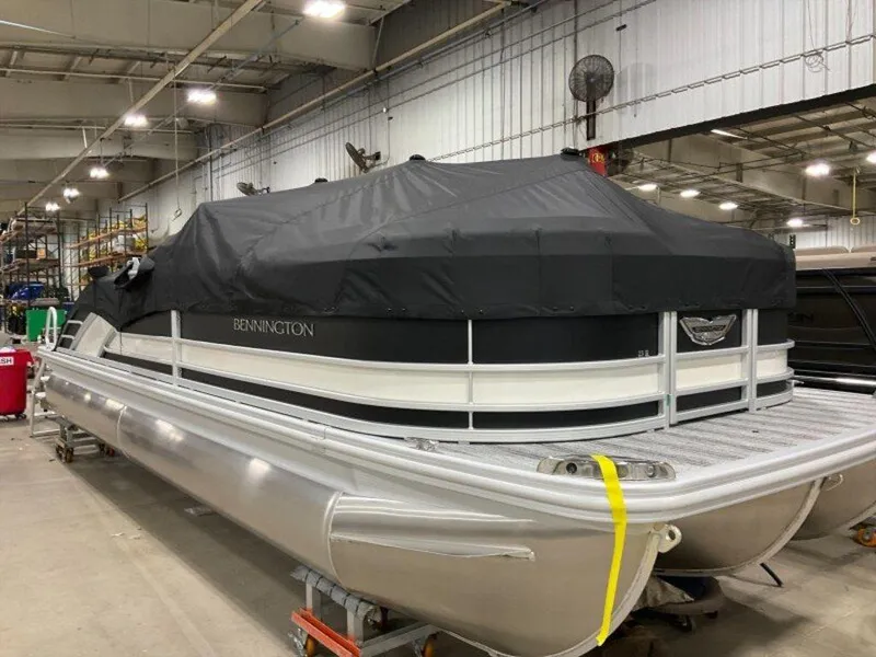 Slide: The Image of 2025 Bennington 23 RSB pontoon boat covered in a warehouse setting. - 22