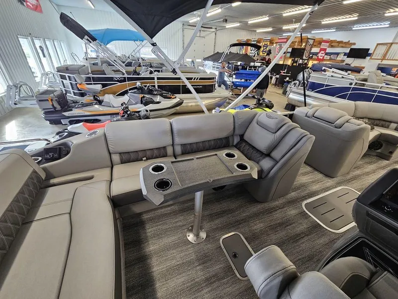 Slide: The Image of 2025 Bennington 23 RSB pontoon boat interior with luxurious seating and table in showroom. - 27