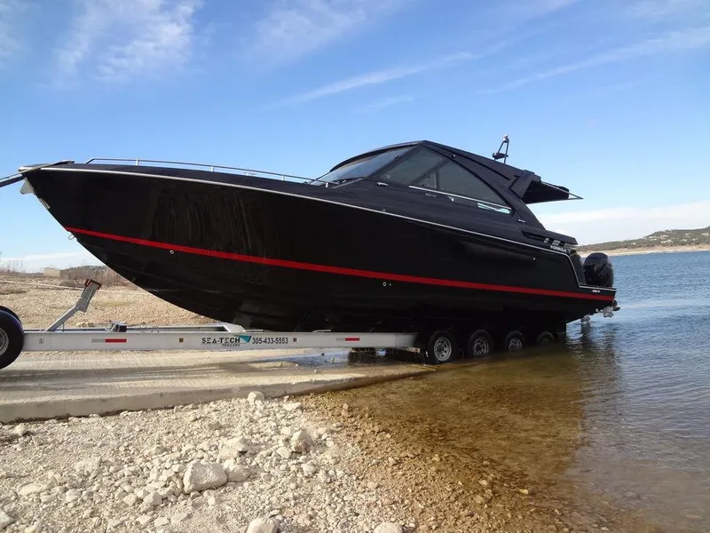 Slide: The Image of 2022 Formula 400 Super Sport Crossover boat on trailer by the water. - 12