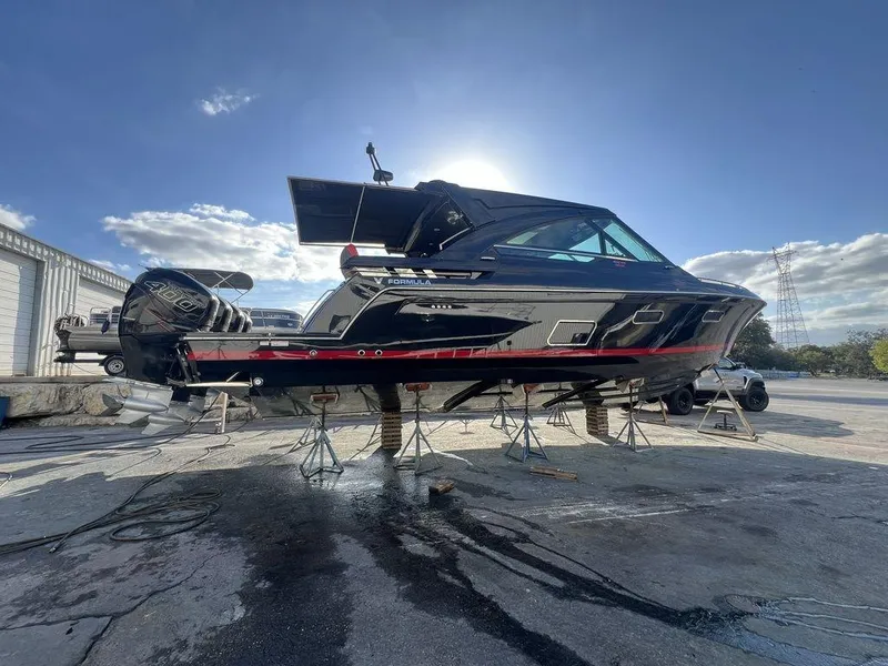 Slide: The Image of 2022 Formula 400 Super Sport Crossover boat on stands, sunlit, with clear sky background. - 20