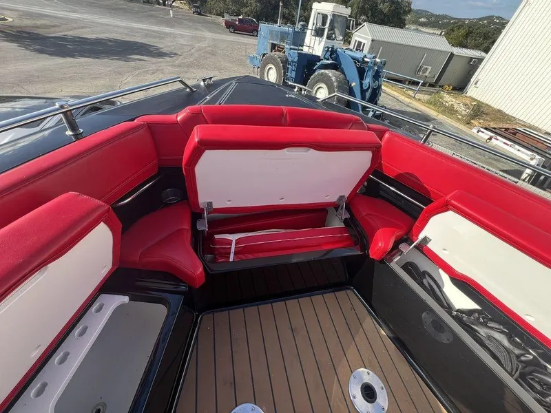 Slide: The Image of 2022 Formula 400 Super Sport Crossover boat with red and white seating, docked outdoors. - 23