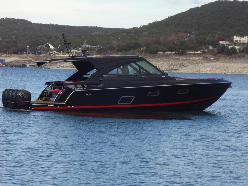 Slide: The Image of 2022 Formula 400 Super Sport Crossover boat on a lake with scenic hills. - 3