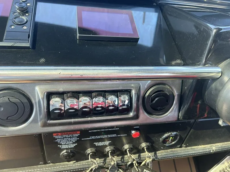 Slide: The Image of Control panel of a 2022 Formula 400 Super Sport Crossover boat, featuring switches and gauges. - 47